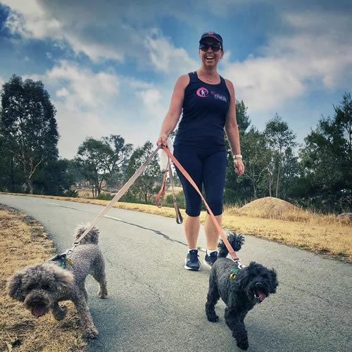 Woman walking 2 dogs.